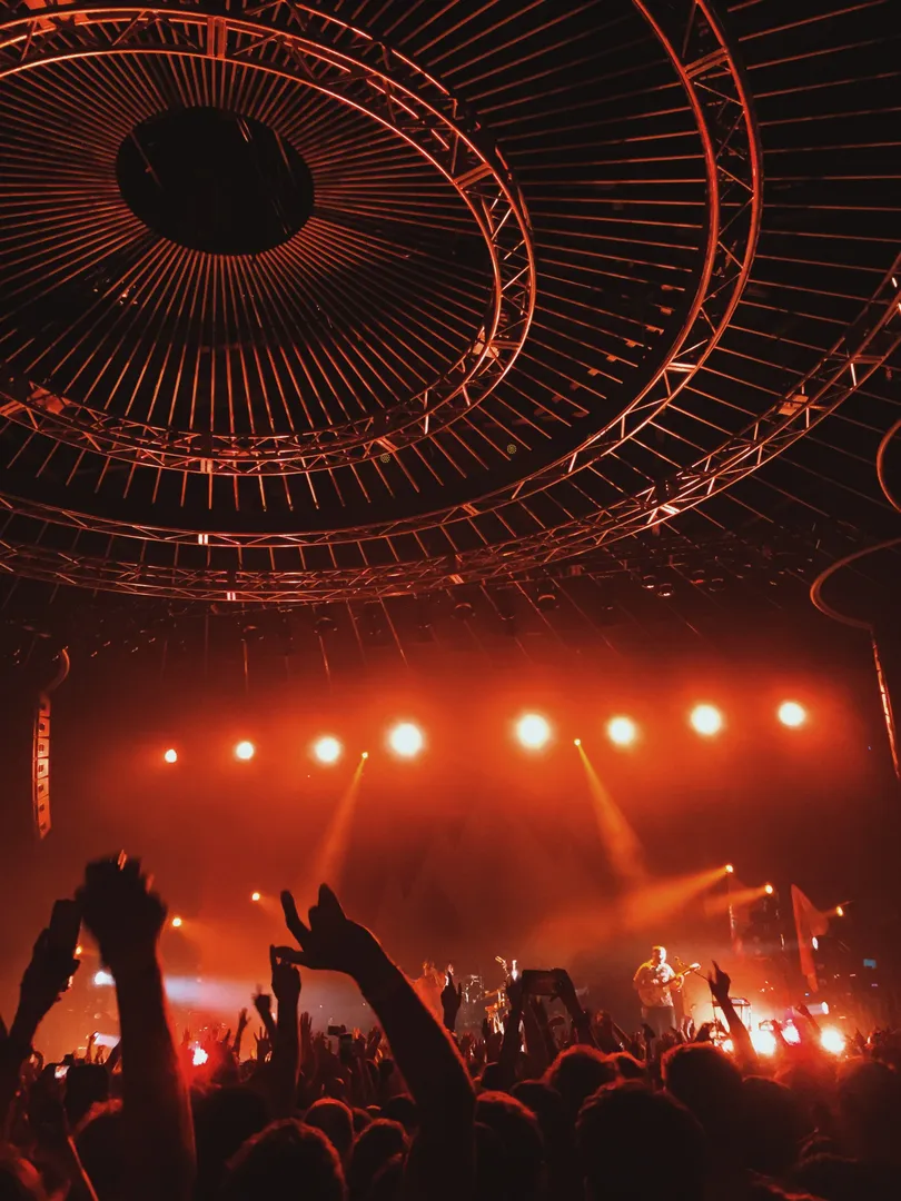 foule assistant à un concert, vue sur les artiste, luminosité ardente