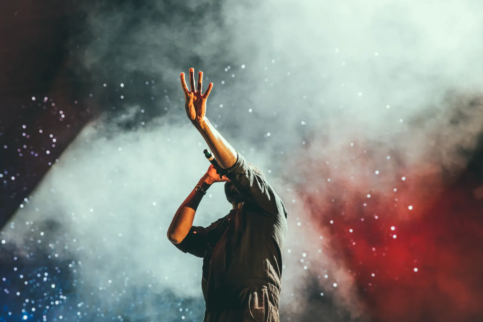 Chanteur sur scène, lumière et effets bleu, blanc, rouge en arrière plan