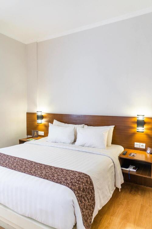 Image de la chambre d'hôtel lumineuse montrant deux lits simples et un bureau