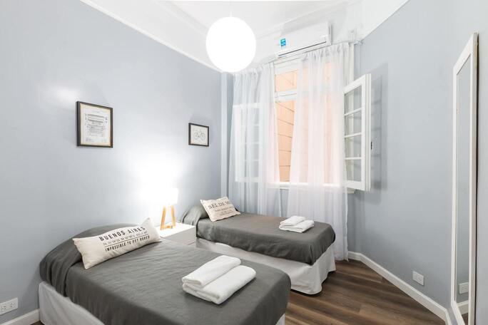 Image de la chambre d'hôtel lumineuse montrant deux lits simples